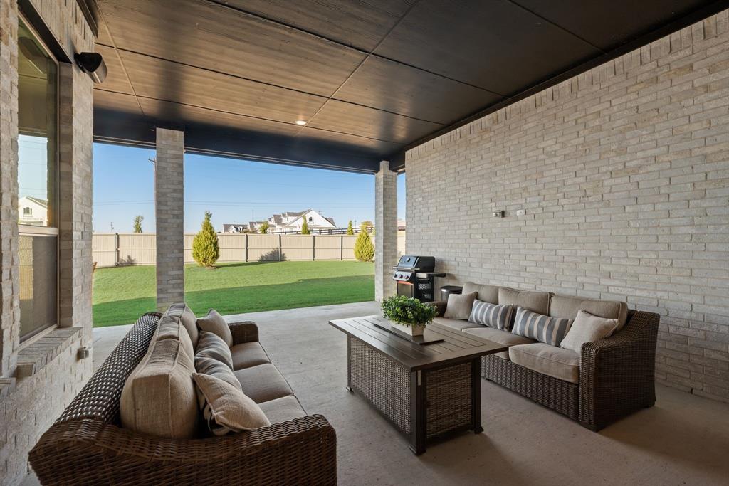 2248 Meander Way Northlake, TX 76247 - Photo 32 of 40 a view of a patio with couches chairs and a floor to ceiling window