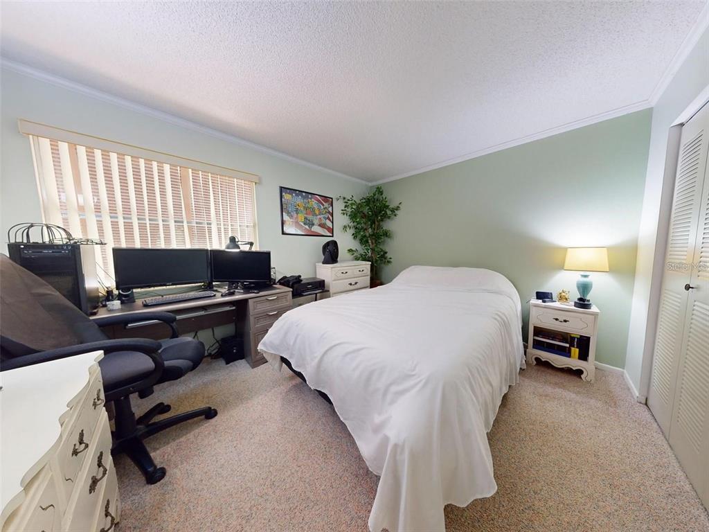 168 Perimeter Court, Unit 5B Deltona, FL 32725 - Photo 20 of 30 a bedroom with a bed and a desk