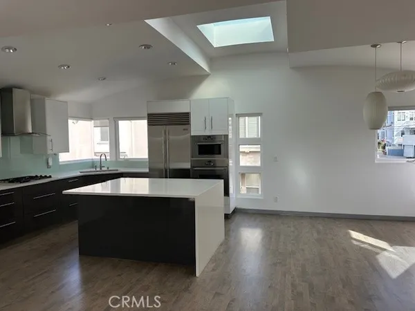 an open kitchen with a sink and a stove top oven