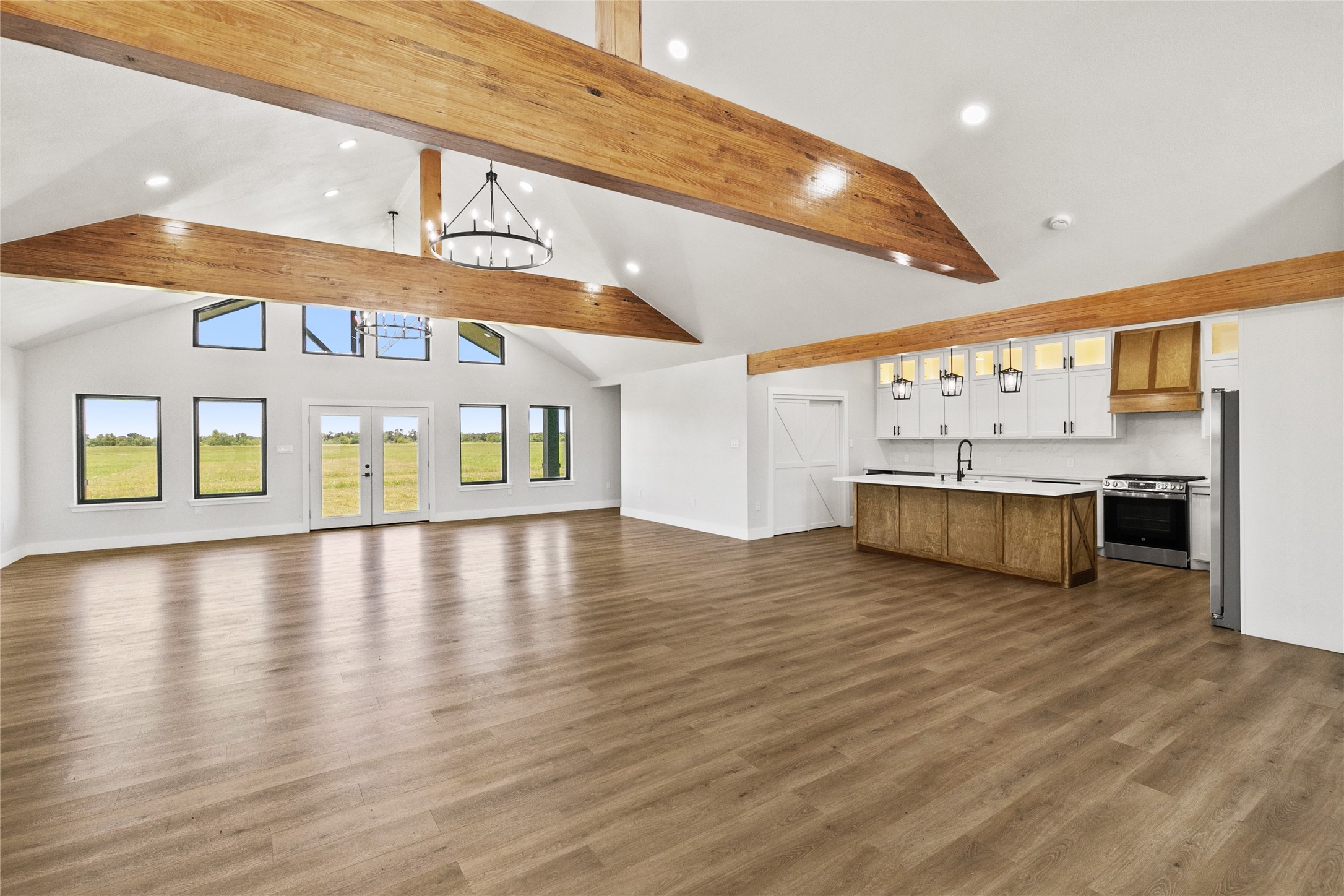 619 Chuckwagon Trail Angleton, TX 77515 - Photo 11 of 37 The open-concept living, dining, and kitchen areas are designed to take advantage of the home's unobstructed views. Vaulted ceilings, exposed beams, and modern lighting create a bright and inviting atmosphere.