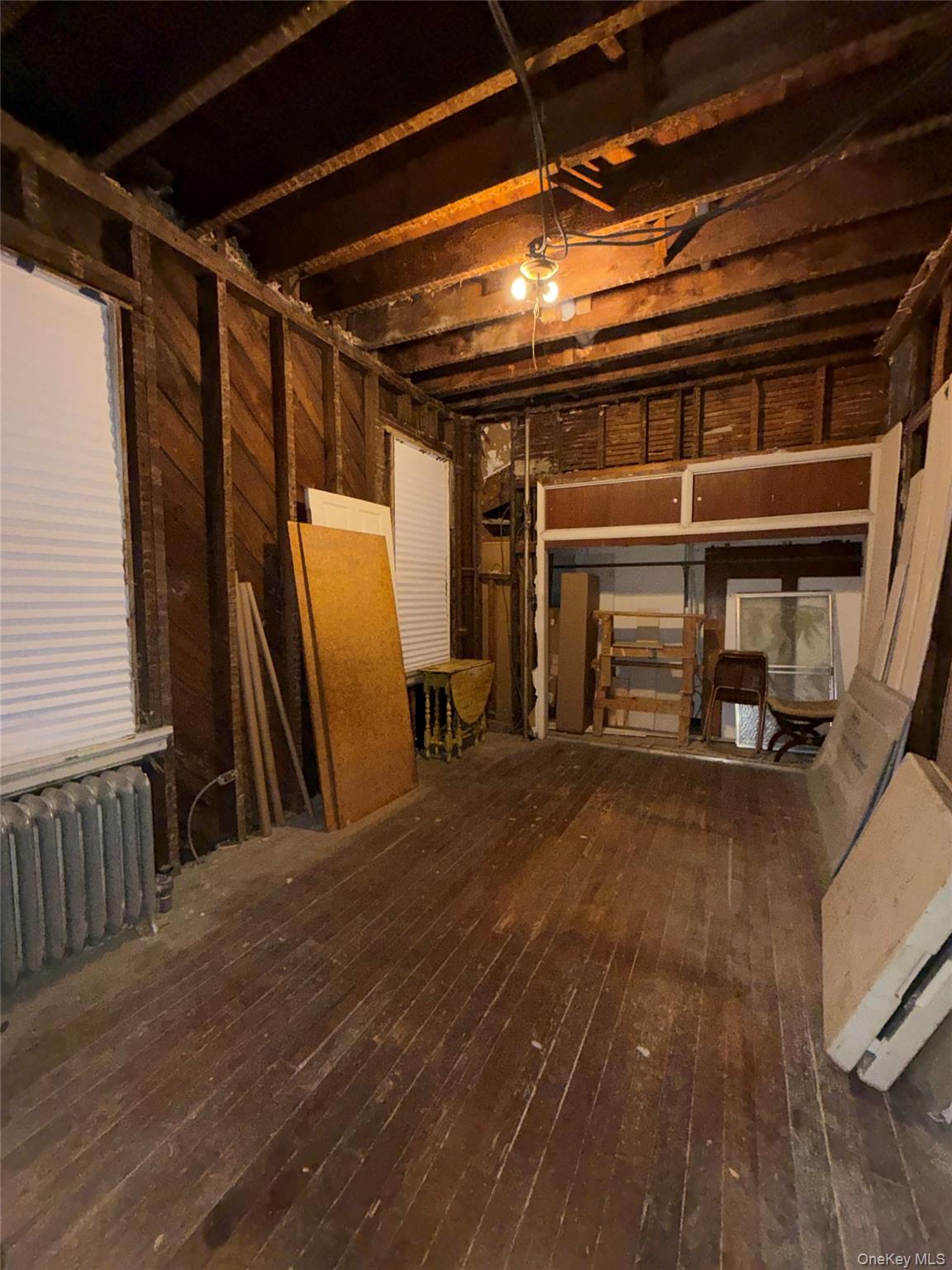 4083 Seton Avenue Bronx, NY 10466 - Photo 6 of 8 Below grade area with radiator, a garage, and dark wood finished floors