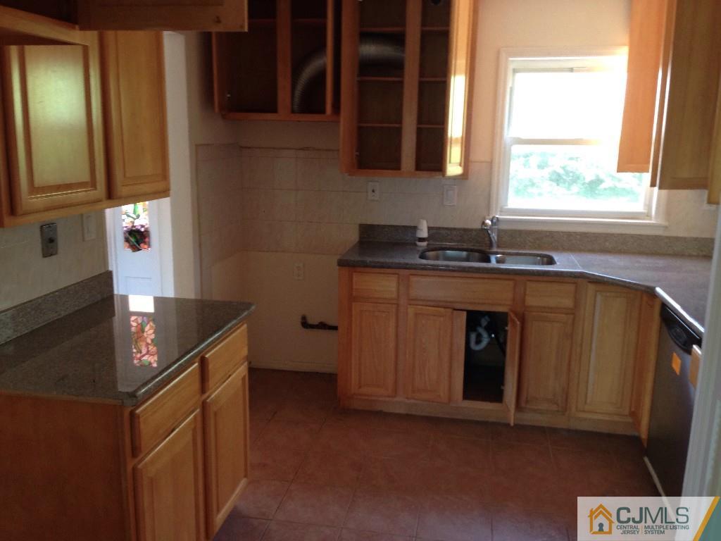 17 Moryan Road Edison, NJ 08817 - Photo 4 of 13 a kitchen with granite countertop a sink stove and cabinets