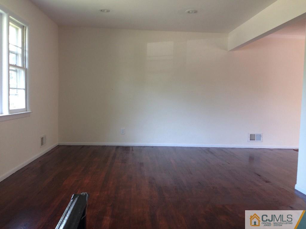 17 Moryan Road Edison, NJ 08817 - Photo 5 of 13 an empty room with wooden floor and windows