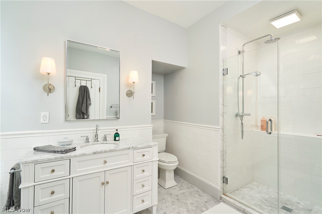 5046 Alger Road Richfield, OH 44286 - Photo 33 of 49 Bathroom featuring a white vanity with a stone countertop, a rectangular mirror, and dual wall sconces