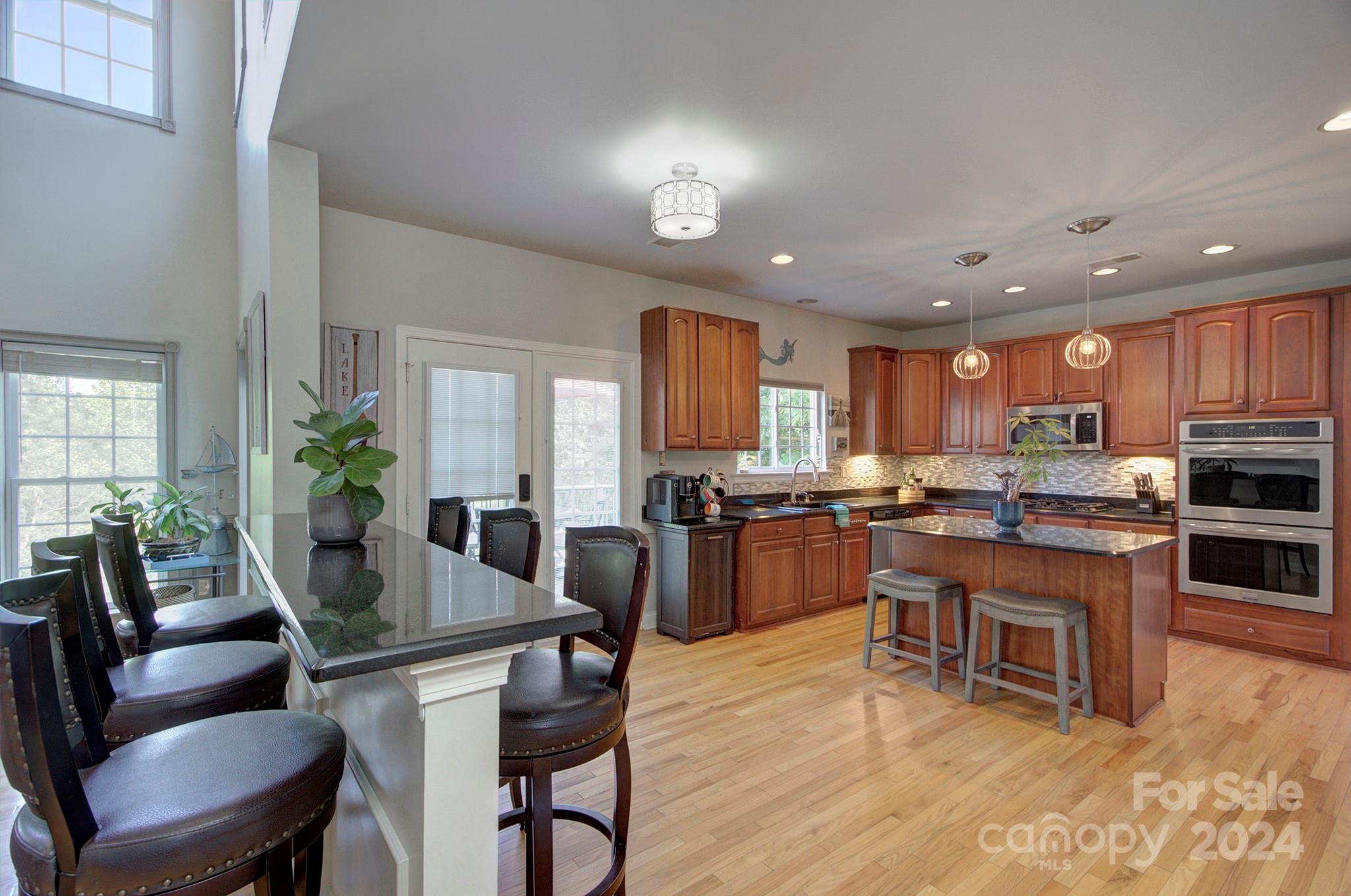 144 Lighthouse Road Mount Holly, NC 28120 - Photo 12 of 48 a living room with furniture a wooden floor and kitchen view