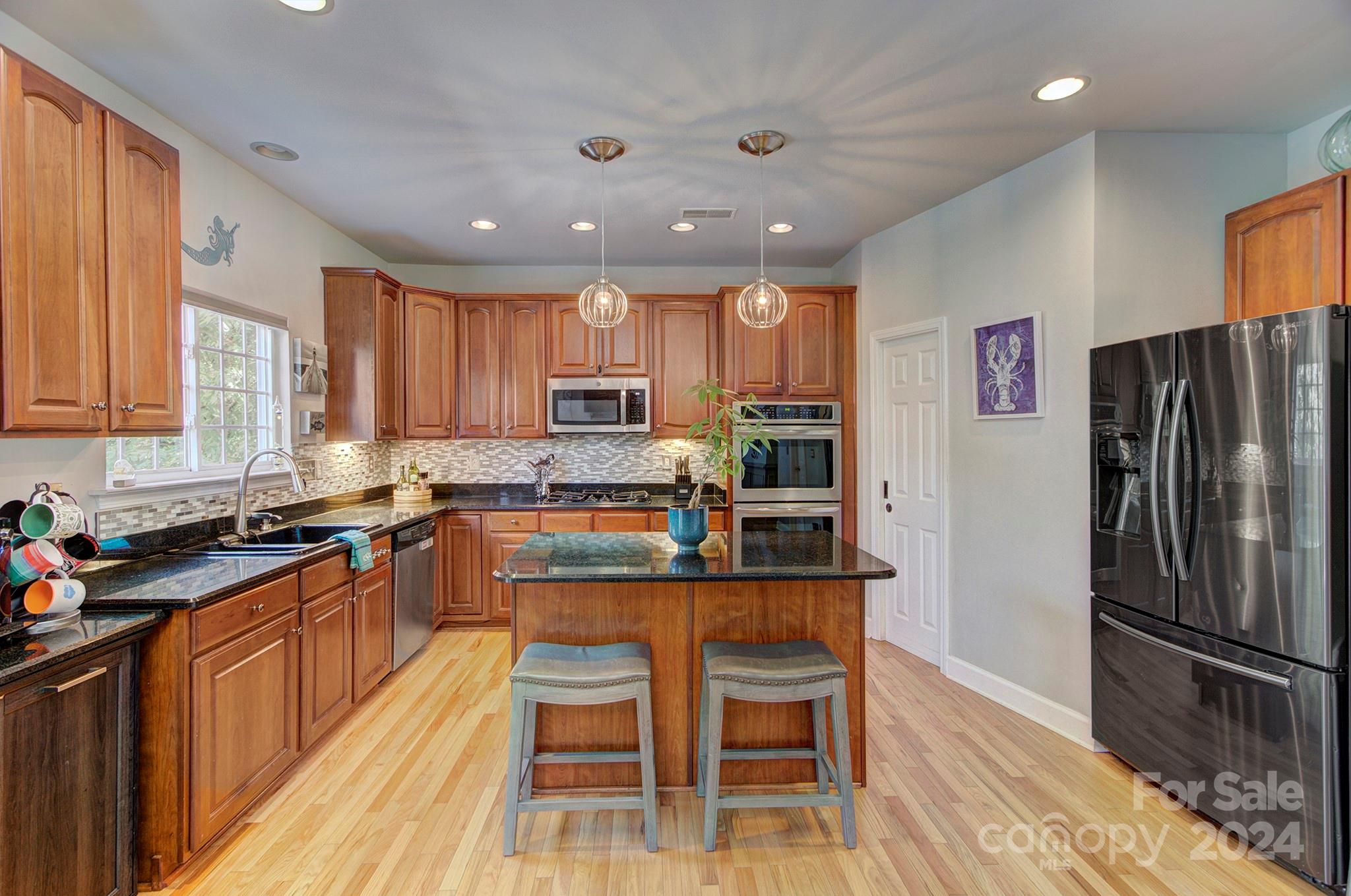 144 Lighthouse Road Mount Holly, NC 28120 - Photo 13 of 48 a kitchen with granite countertop stainless steel appliances a refrigerator a stove a sink a dining table and chairs