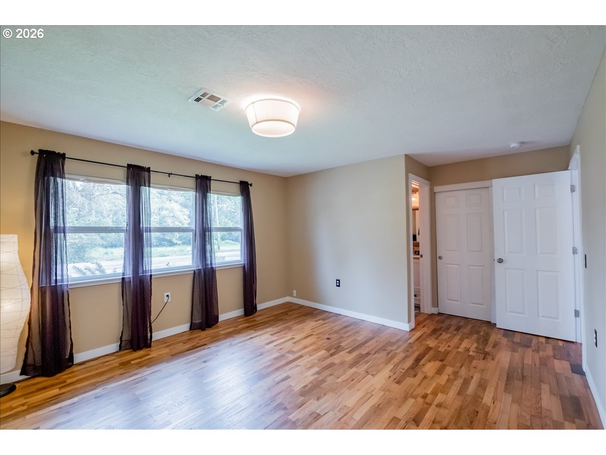 32973 Tennessee Road Southeast Lebanon, OR 97355 - Photo 16 of 36 a view of an empty room with window and wooden floor