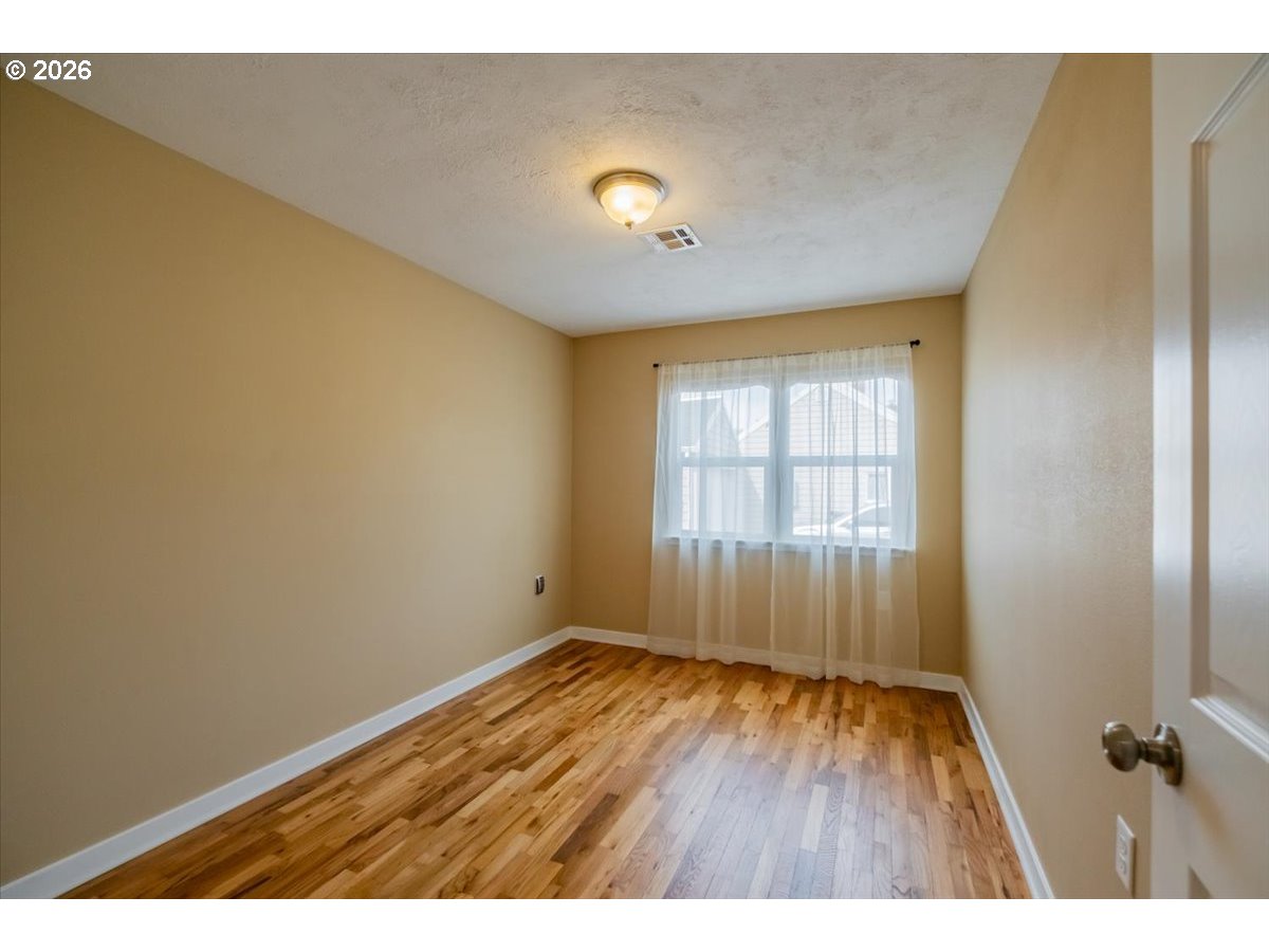 32973 Tennessee Road Southeast Lebanon, OR 97355 - Photo 22 of 36 a view of an empty room with wooden floor and a window