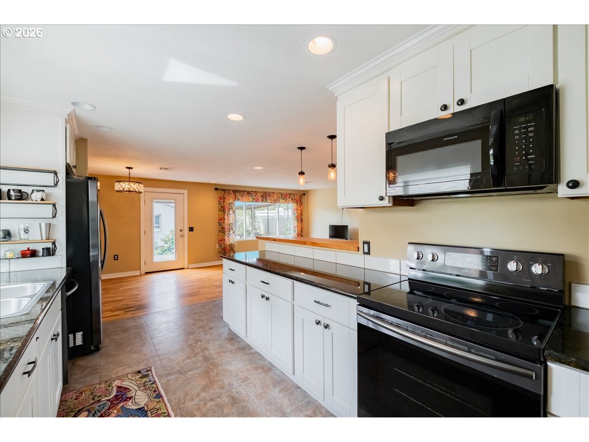 32973 Tennessee Road Southeast Lebanon, OR 97355 - Photo 10 of 36 a kitchen with stainless steel appliances granite countertop a stove a sink and a microwave