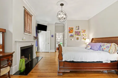 a bedroom with a bed and wooden floor