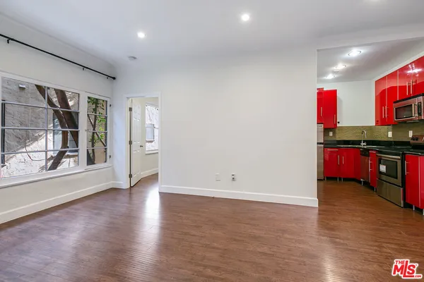 an empty room with wooden floor and cabinet