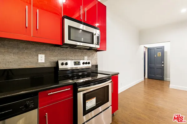 a kitchen with stainless steel appliances granite countertop a stove microwave and oven