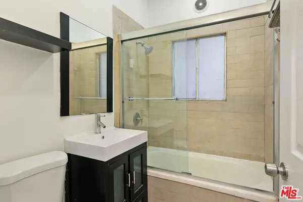 a bathroom with a sink mirror and a shower