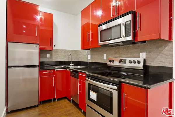 a kitchen with stainless steel appliances granite countertop a stove a microwave and a refrigerator