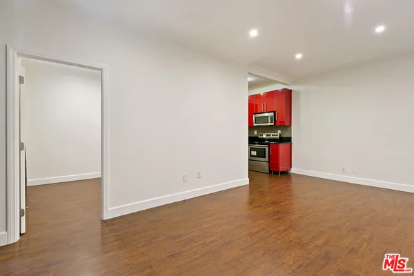 a view of an empty room with wooden floor