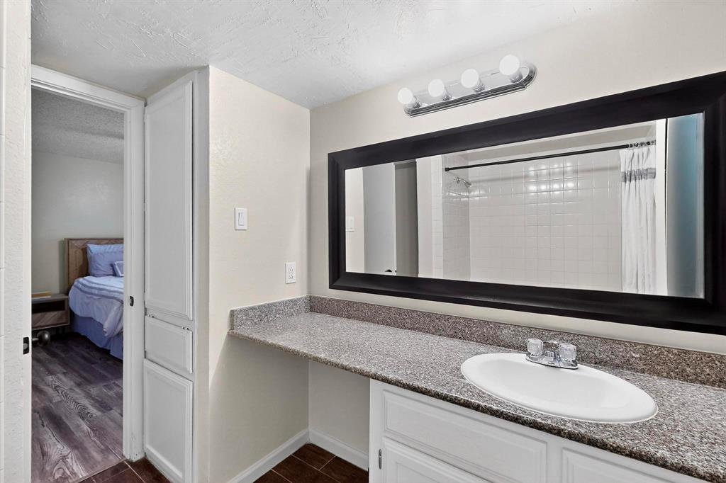 9611 Walnut Street, Unit 1105 Dallas, TX 75081 - Photo 14 of 24 a en suite bathroom with a granite countertop sink and a mirror