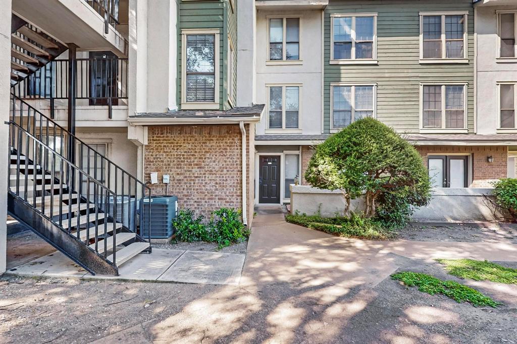 9611 Walnut Street, Unit 1105 Dallas, TX 75081 - Photo 4 of 24 a view of a brick house with many windows plants and large tree