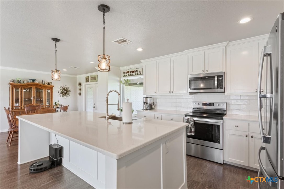 17179 Cyclone Road Burlington, TX 76519 - Photo 14 of 39 a kitchen with stainless steel appliances granite countertop a sink a stove and a refrigerator