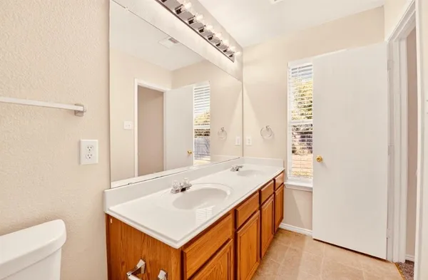 a bathroom with a sink a toilet and a mirror