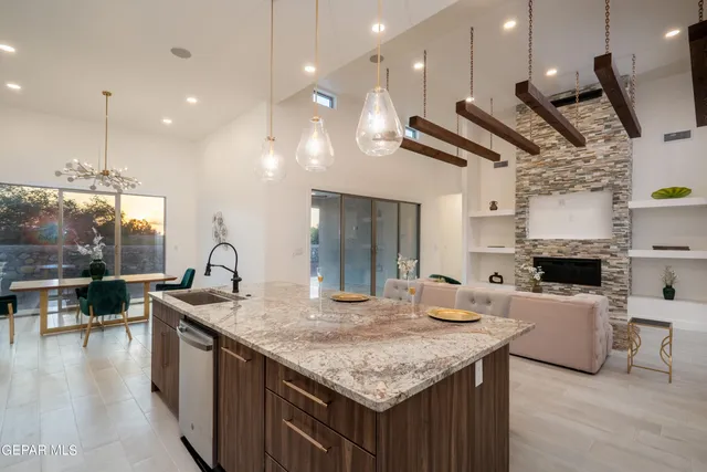 a kitchen with granite countertop a sink a counter top space stainless steel appliances and a counter top space