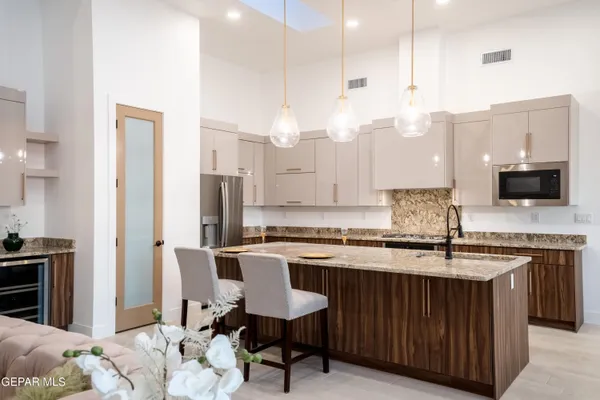 a kitchen with stainless steel appliances kitchen island granite countertop a sink and cabinets