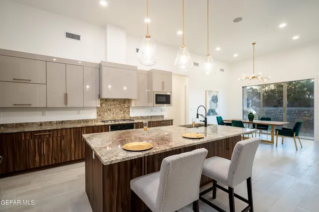 a dining table with chairs and kitchen view