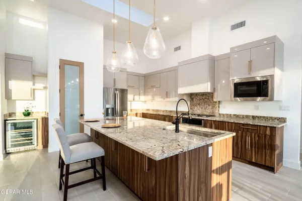 a kitchen with granite countertop a sink a counter top space appliances and cabinets