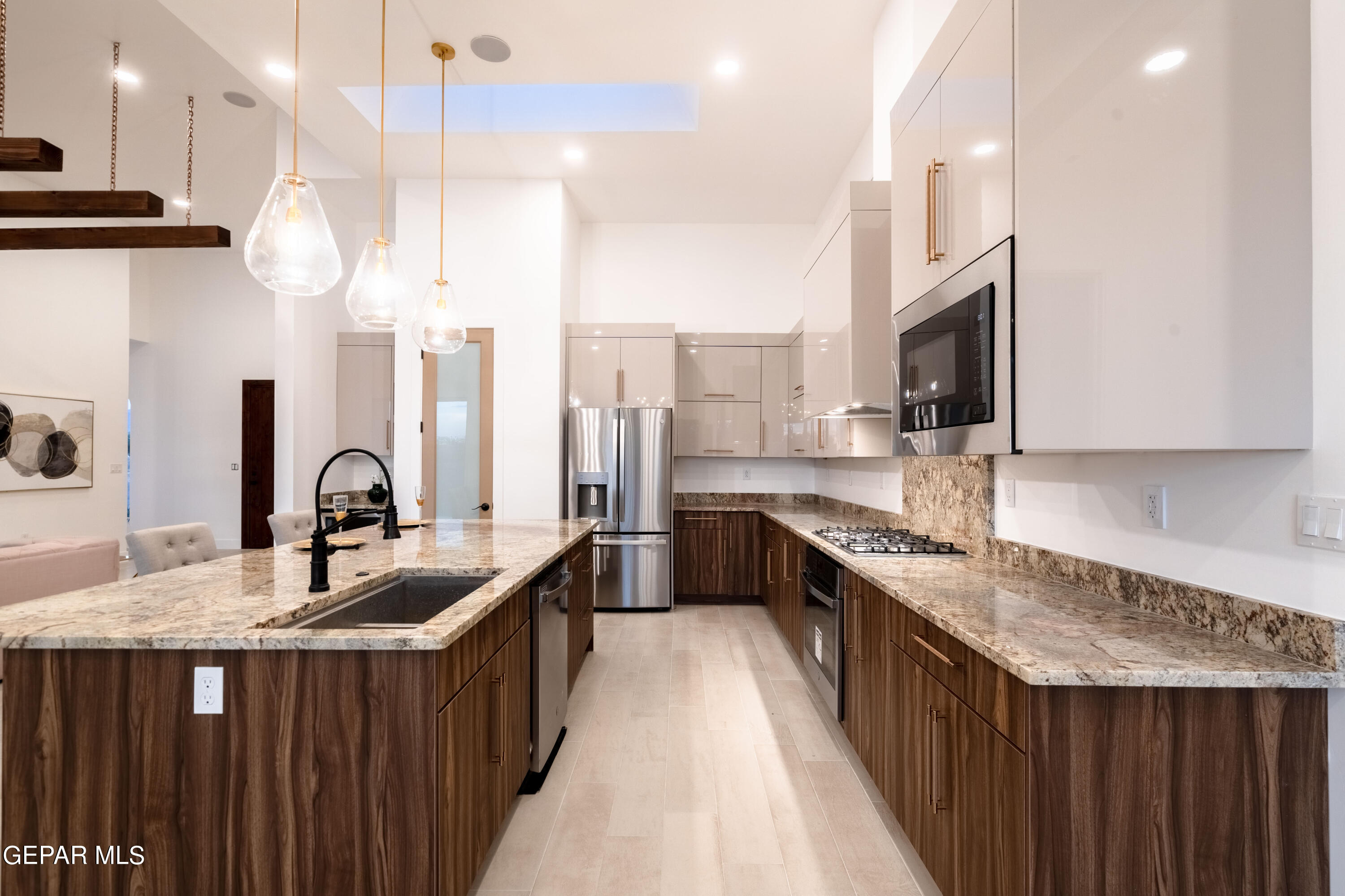 5692 Rio Bonito Circle El Paso, TX 79932 - Photo 17 of 46 a kitchen with stainless steel appliances granite countertop a sink a stove and a wooden floors