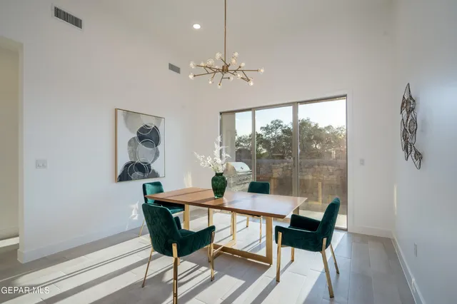 a dining room with furniture a chandelier and wooden floor