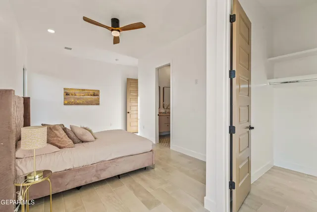 a bedroom with a bed and a ceiling fan