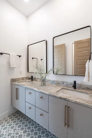 a bathroom with a granite countertop sink and a mirror