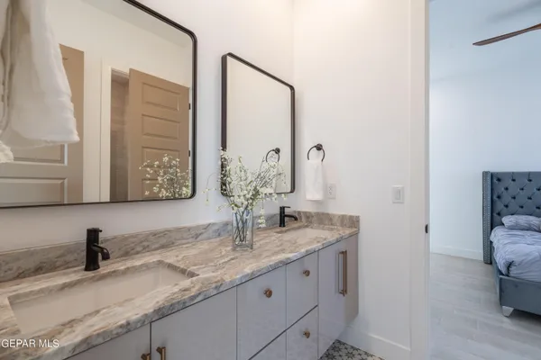 a bathroom with a granite countertop sink and a mirror