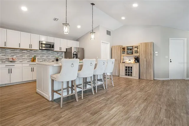 a large kitchen with lots of counter space dining table and stainless steel appliances