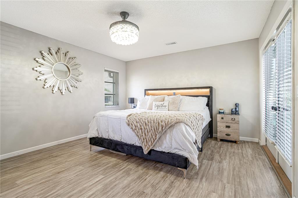 5807 Garfield Road Venice, FL 34293 - Photo 15 of 40 a bedroom with a bed and a chandelier