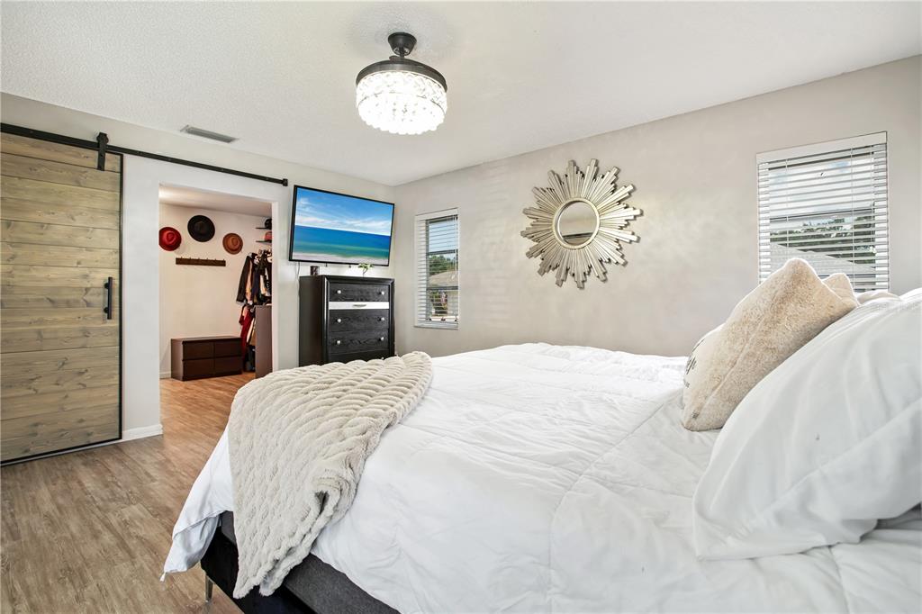 5807 Garfield Road Venice, FL 34293 - Photo 17 of 40 a bedroom with a bed and a chandelier