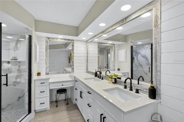 a bathroom with a double vanity sink mirror and shower