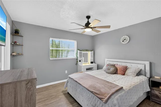 a bedroom with a large bed and a ceiling fan
