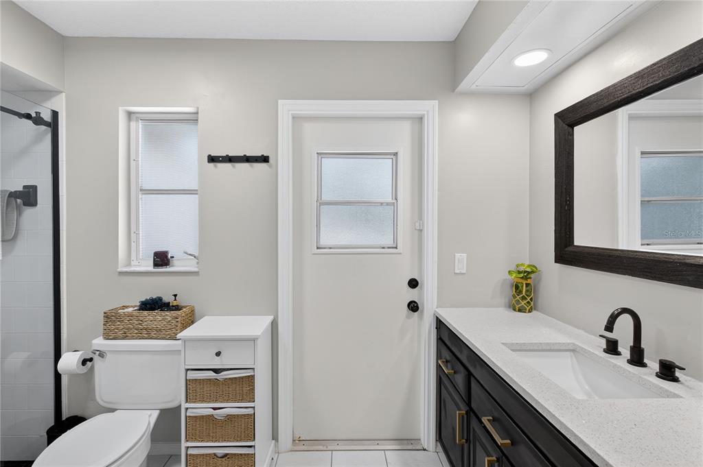 5807 Garfield Road Venice, FL 34293 - Photo 25 of 40 a bathroom with a granite countertop sink toilet and mirror