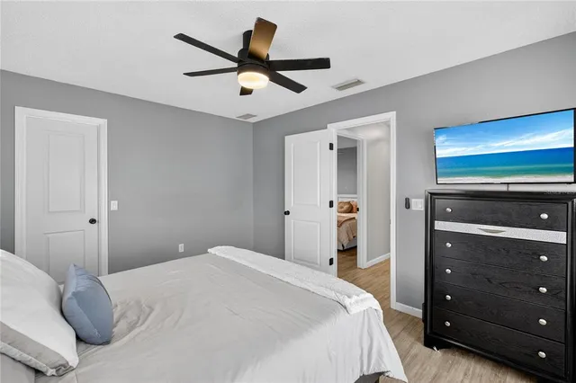 a bedroom with a bed and a ceiling fan