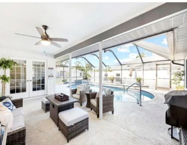 a living room with furniture ceiling fan and a large window