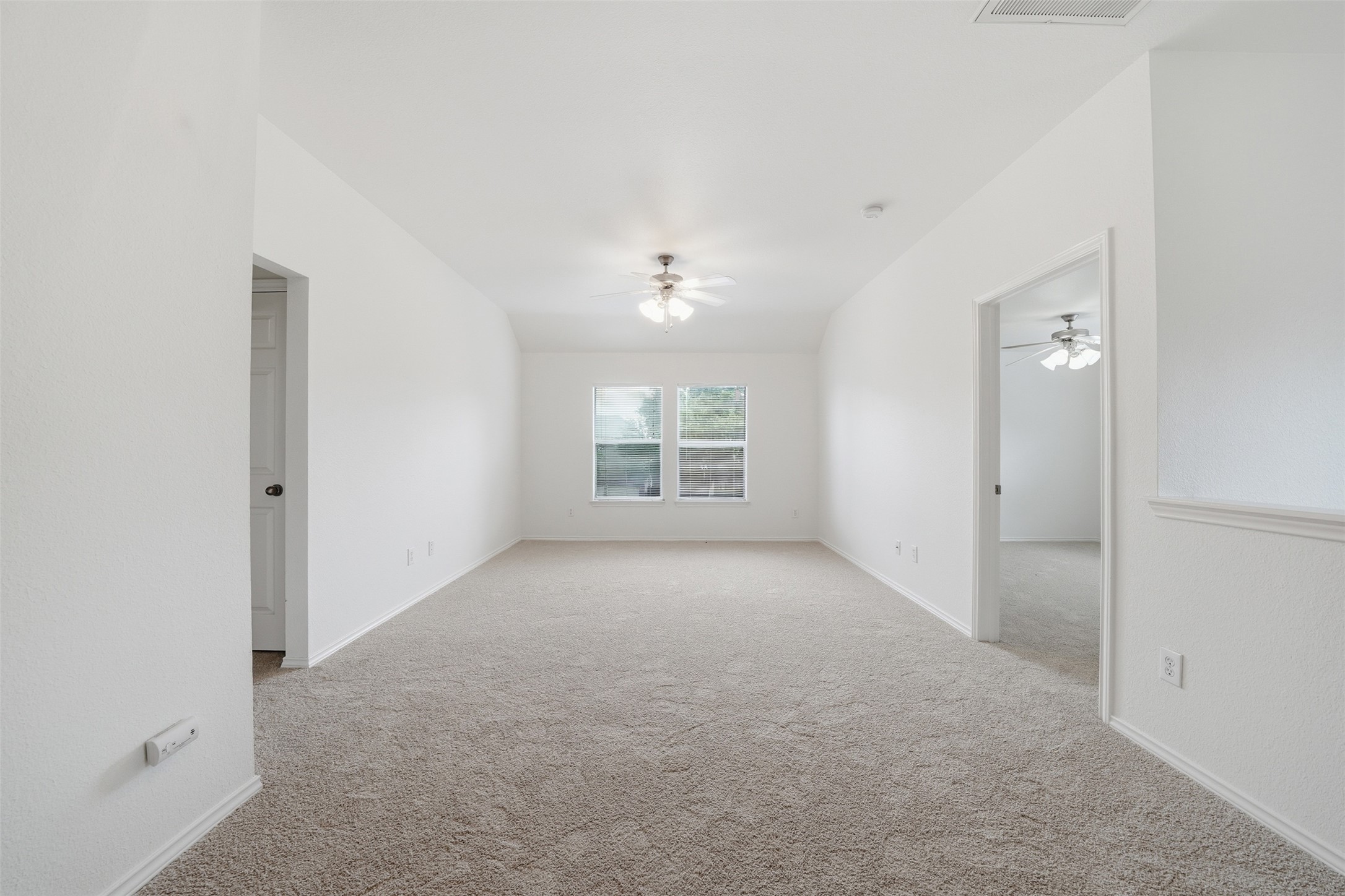 118 Invierno Street Kyle, TX 78640 - Photo 18 of 37 A spacious, naturally illuminated room featuring plush carpeting and a modern ceiling fan.