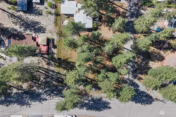 an aerial view of residential house with outdoor space and trees all around