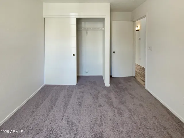 an empty room with closet and mirror