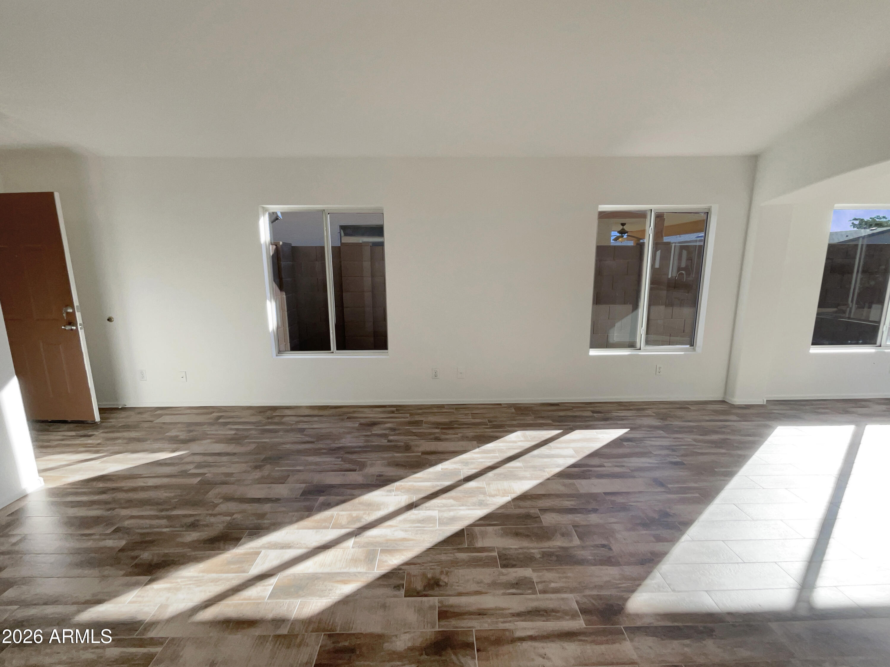 2023 East Wagoner Road Phoenix, AZ 85022 - Photo 7 of 22 a view of a livingroom with an empty space & wooden floor