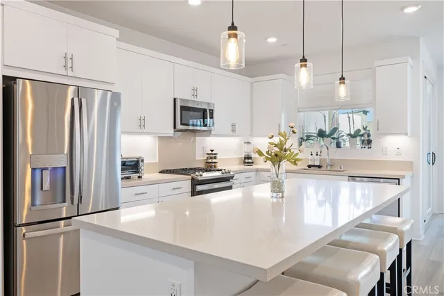a kitchen with stainless steel appliances kitchen island a refrigerator and a stove top oven