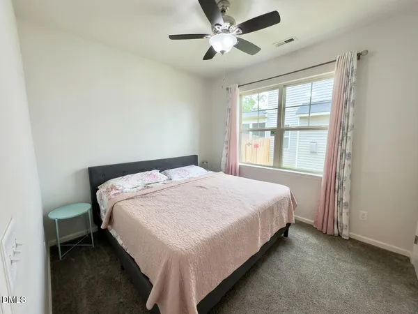 a bedroom with a bed and a ceiling fan