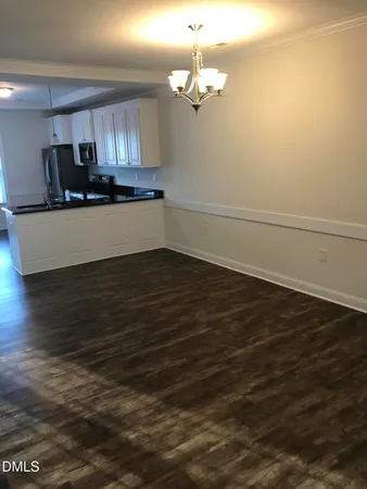 a view of a kitchen with an empty space and wooden floor