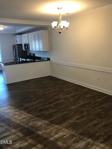 a view of a kitchen with an empty space and wooden floor