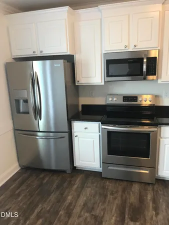 a kitchen with appliances a microwave and cabinets