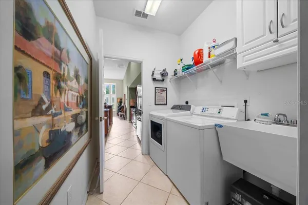 a utility room with cabinets washer and dryer